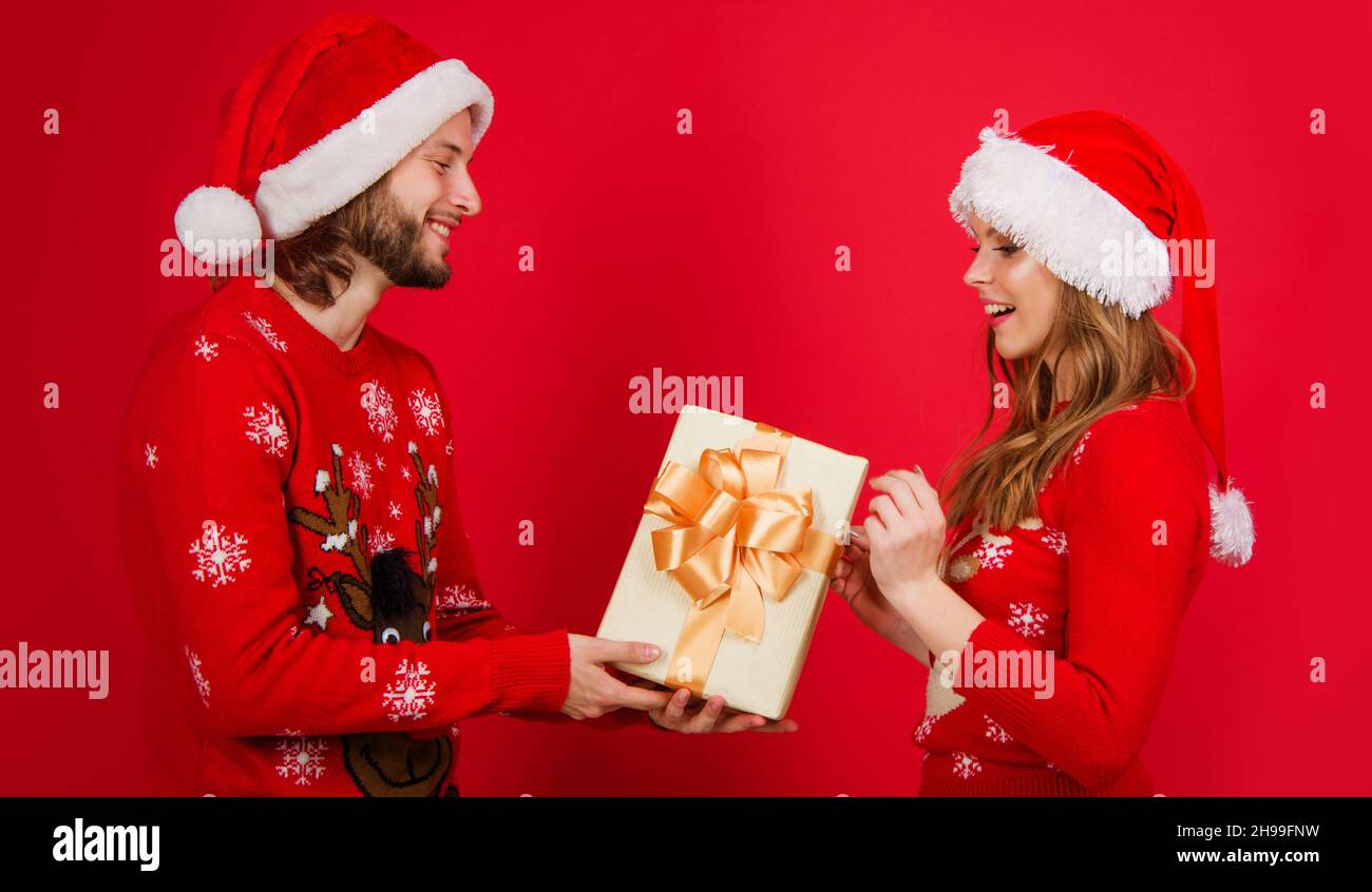 Joyeux couple de père Noël en chandail rouge chapeau de Noël avec boîte cadeau.Bonne fête du nouvel an Banque D'Images