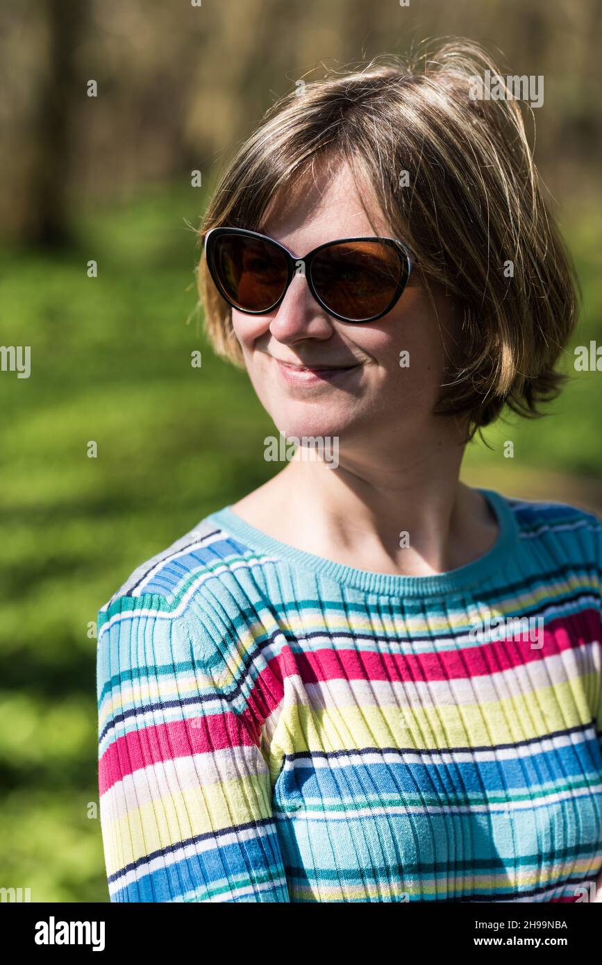 Photo de mode colorée d'une femme de 30 ans avec un jersey coloré et des  lunettes de soleil dans un fond de nature Photo Stock - Alamy
