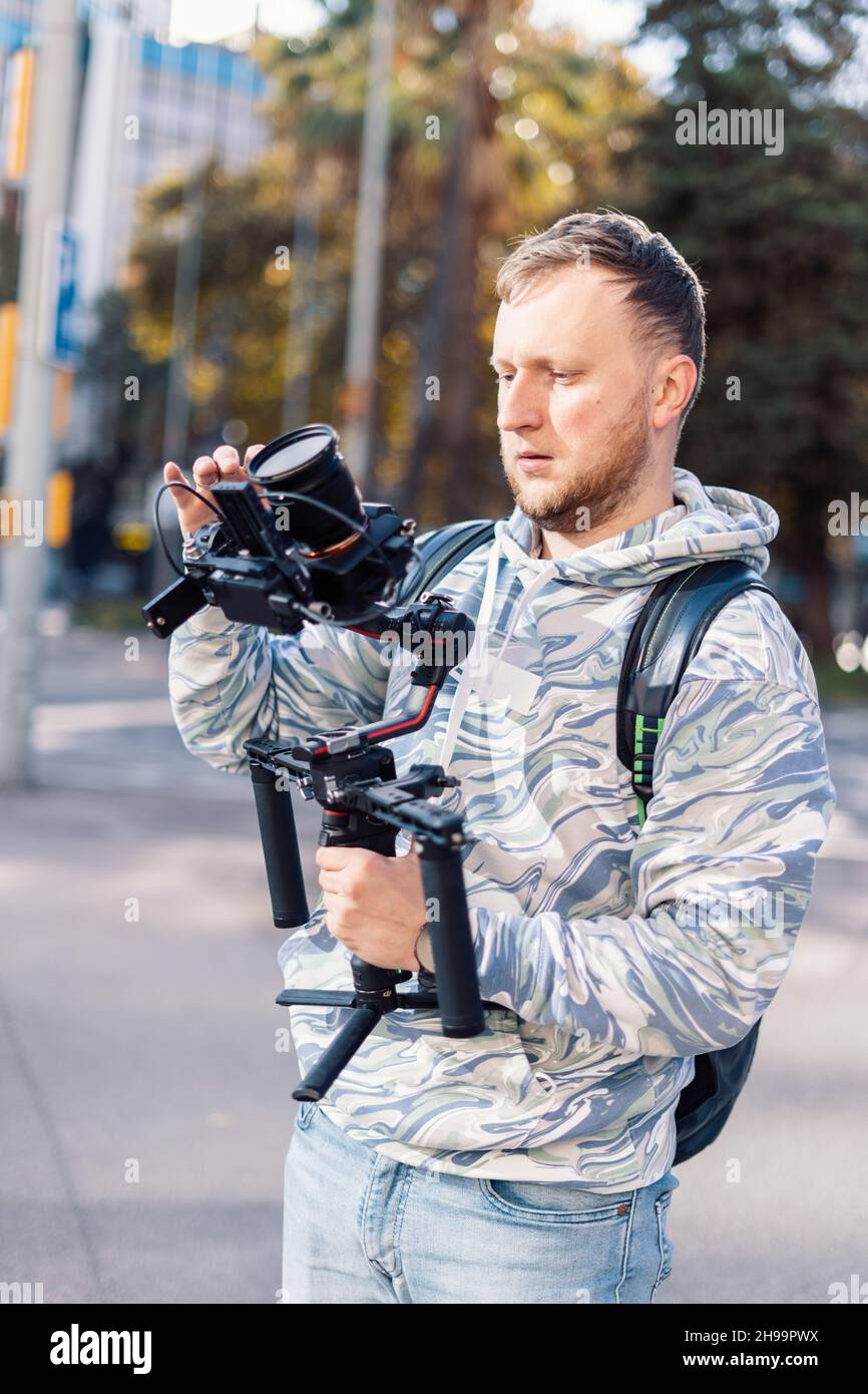 Vidéaste professionnel avec ballon d'exercice effectuant la configuration de l'équipement vidéo avant le tournage.Il équilibre la caméra Banque D'Images