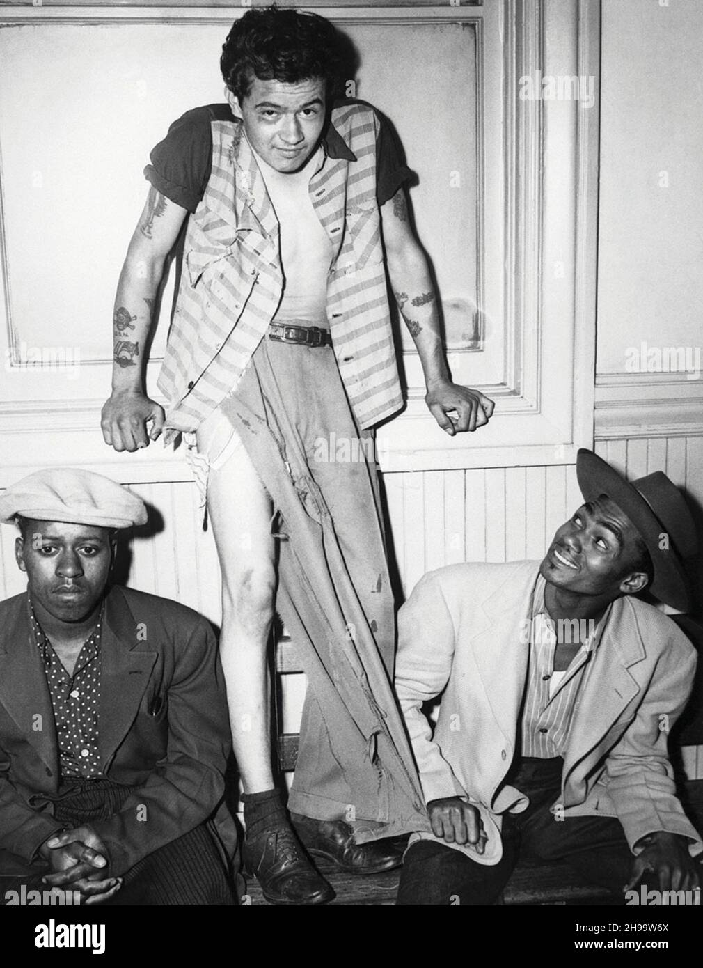 Paul Acevedo se tient dans ses vêtements en lambeaux, flanqués par deux hommes en costume de zoot après la 'bataille de Gangland' à Los Angeles, Californie.Depuis Ma Banque D'Images