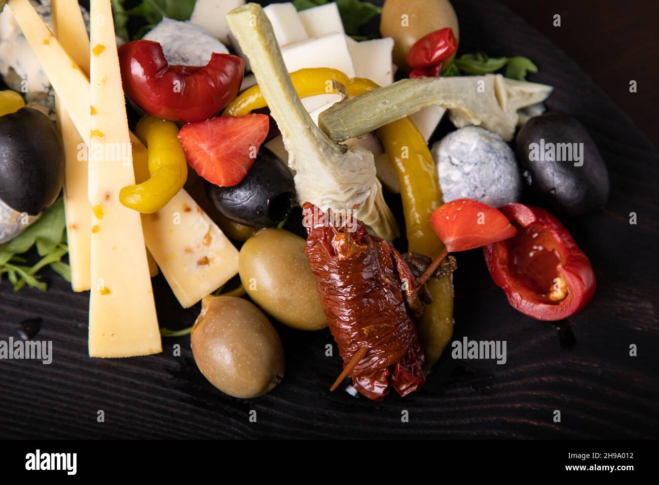 Palette de nombreux types de fromage et quelques légumes, tomates, paprika, olives. Banque D'Images