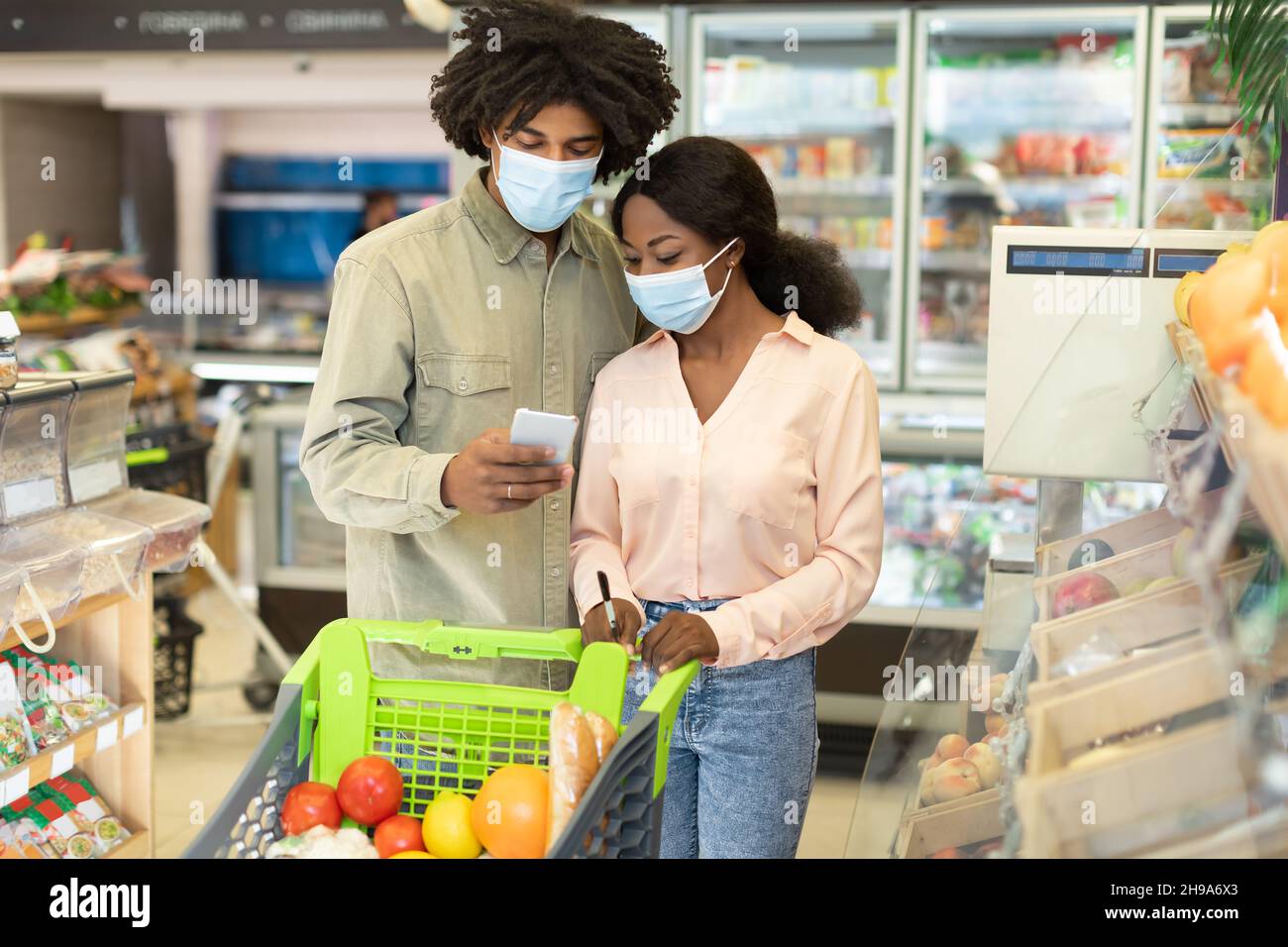 Black couple Shopping courses à l'aide de l'application smartphone dans le magasin Banque D'Images