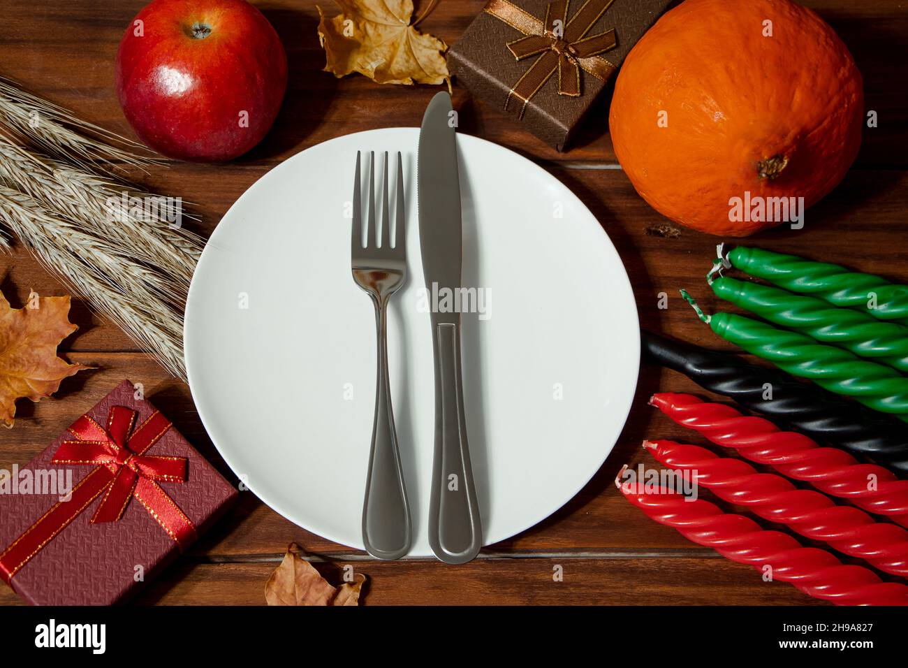 Table festive pour la fête de Kwanzaa en Afrique-américaine.Symboles du patrimoine africain.Sept bougies en rouge, noir et vert.Récolte et cadeaux Banque D'Images