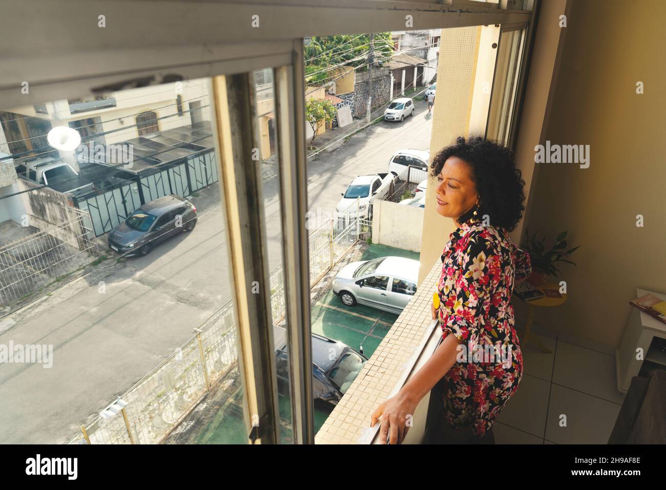 Portrait d'une femme à la fenêtre donnant sur la rue.Salvador, Bahia, Brésil. Banque D'Images