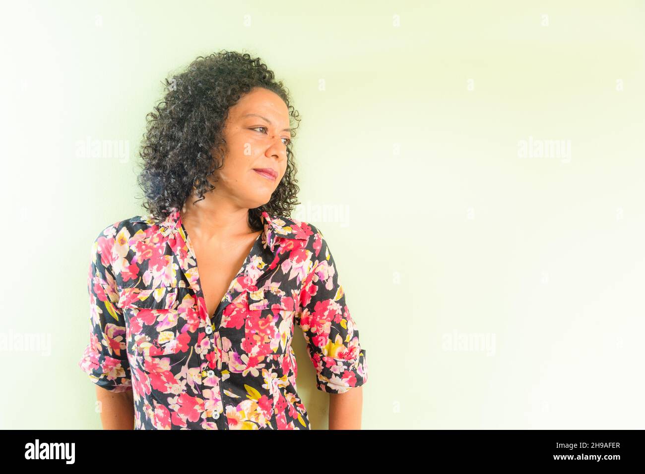 Portrait d'une femme sur fond vert clair.Salvador, Bahia, Brésil. Banque D'Images