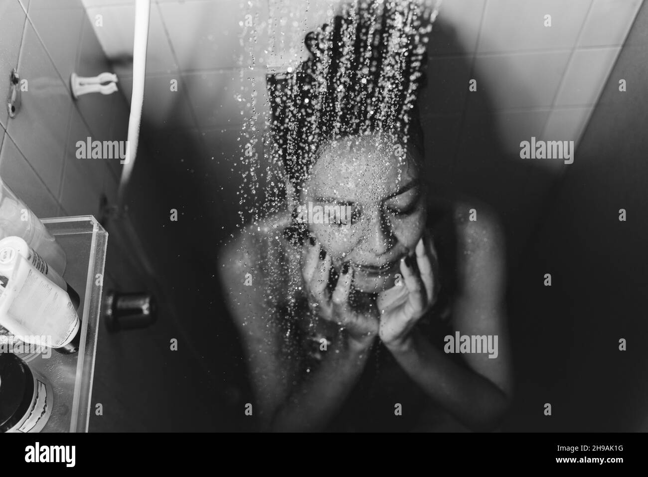 Portrait d'une femme dans la salle de bains se lavant elle-même.Salvador, Bahia, Brésil. Banque D'Images
