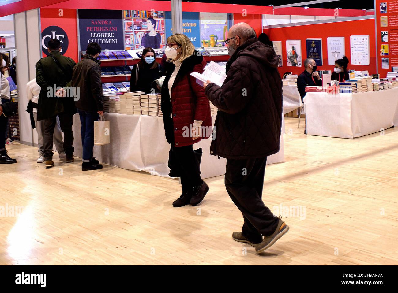 Rome, Italie.05e décembre 2021.Un visiteur parcourt son nouveau livre, acheté dans l'un des stands de la Foire nationale des petites et moyennes éditions 'Più Libri Più Liberi'.'Più Libri Più Liberi' est le premier salon italien entièrement dédié exclusivement à l'édition où chaque année environ 500 éditeurs, venant de toute l'Italie,présenter leurs nouvelles et leur catalogue au public.Crédit : SOPA Images Limited/Alamy Live News Banque D'Images