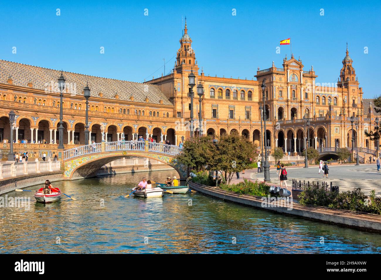Plaza de Espana, les gens ramer bateau sur la douve avec des ponts représentant les quatre anciens royaumes de l'Espagne, Séville, province de Séville, Andalousie Aut Banque D'Images