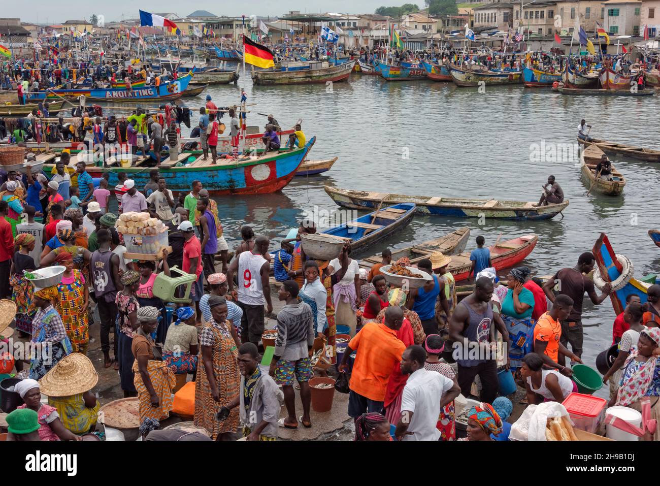 Personnes attendant que les bateaux de pêche entrent dans le port, Elmina, région centrale, Ghana Banque D'Images