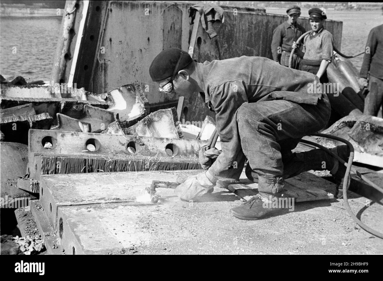 Gdynia, 1947-09.Port Gdynia.NZ. Prace demonta¿owe na wraku pancernika niemieckiego Gneisenau zatopionego u wejœcia do portu podczas II wojny œwiatowej.Spawacz tnie palnikiem metalowe elementy wraku. bk/mgs PAPGdynia, 1947 septembre.Port de Gdynia.Photo : démantèlement d'une épave du cuirassé allemand Gneisenau coulé dans le port pendant la Seconde Guerre mondialeUn soudeur coupant des éléments métalliques de l'épave. bk/mgs PAP Banque D'Images