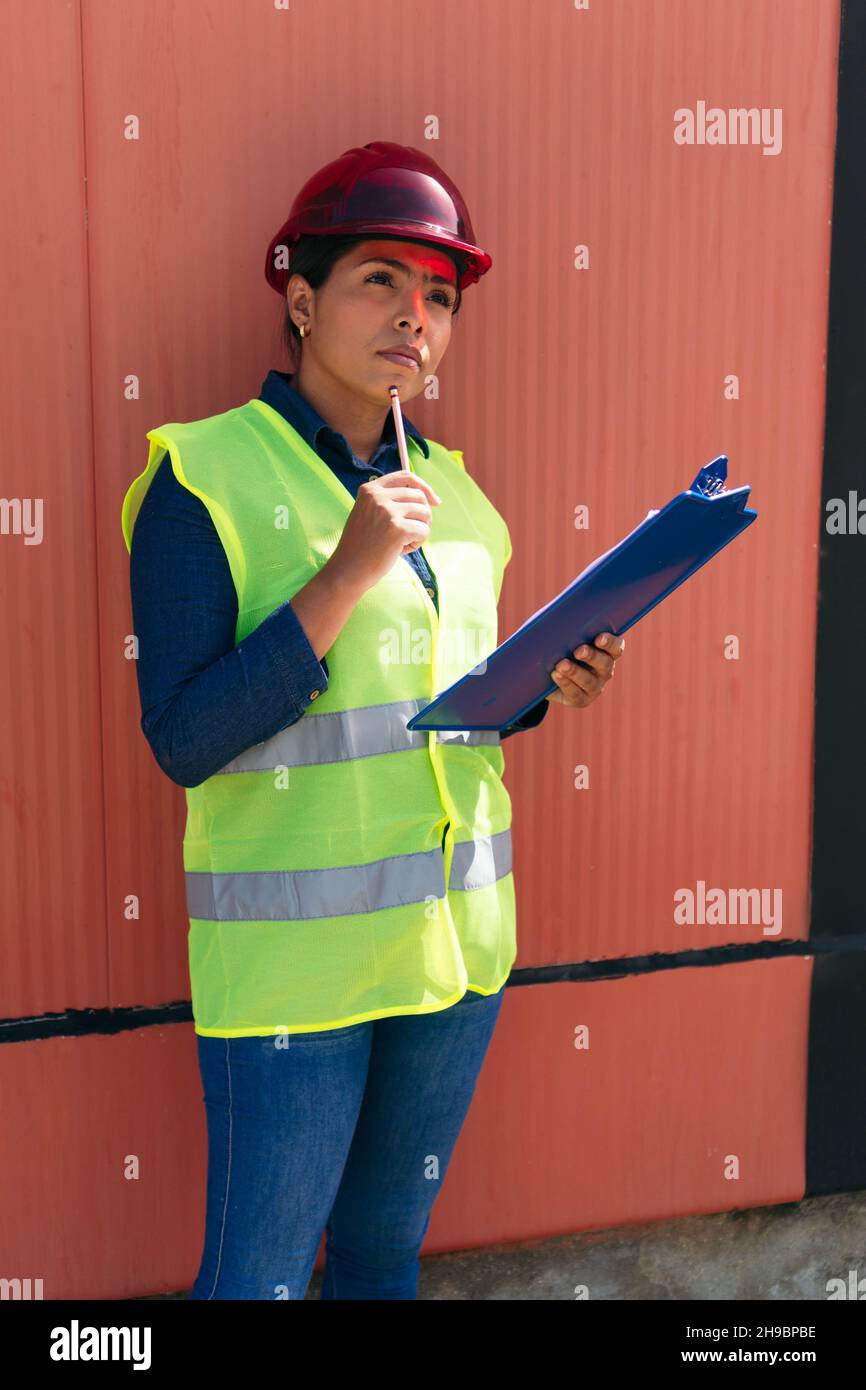 Jeune femme portant un gilet de protection dans une usine Banque D'Images