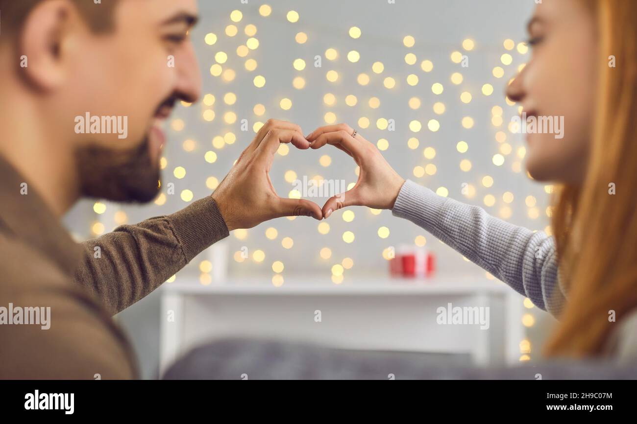 J'aime un jeune couple heureux qui forme le cœur des doigts ensemble Banque D'Images