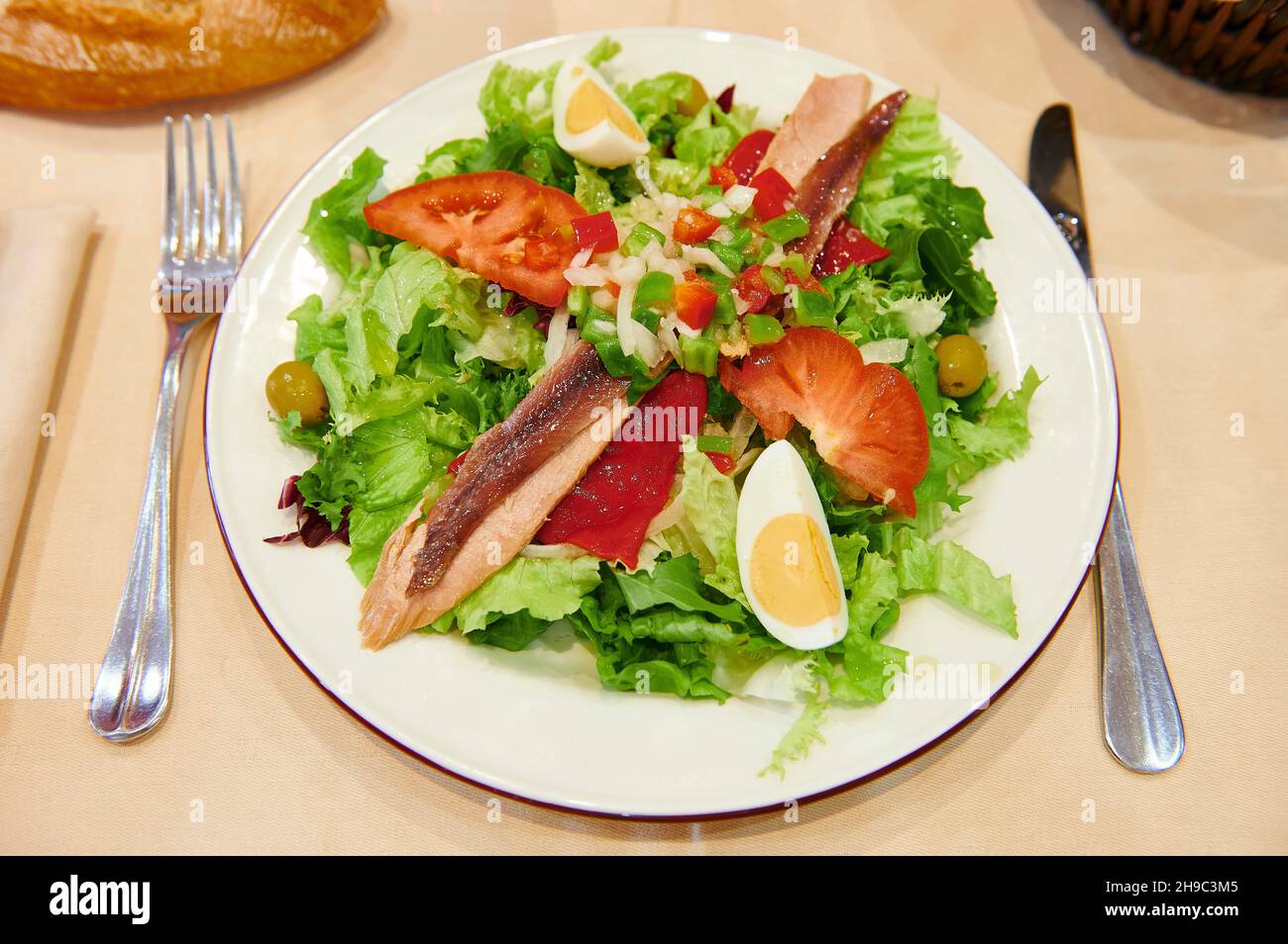Aliments sains, salade de thon, œufs, anchois, tomates,olives et poivrons rouges Banque D'Images