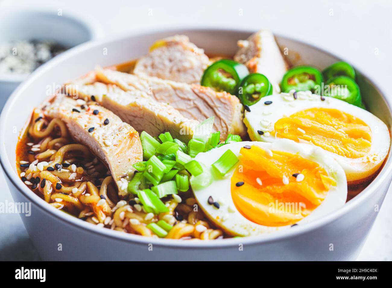 Soupe asiatique de nouilles ramen avec poulet et œuf dans un bol gris, gros plan.Concept alimentaire japonais. Banque D'Images