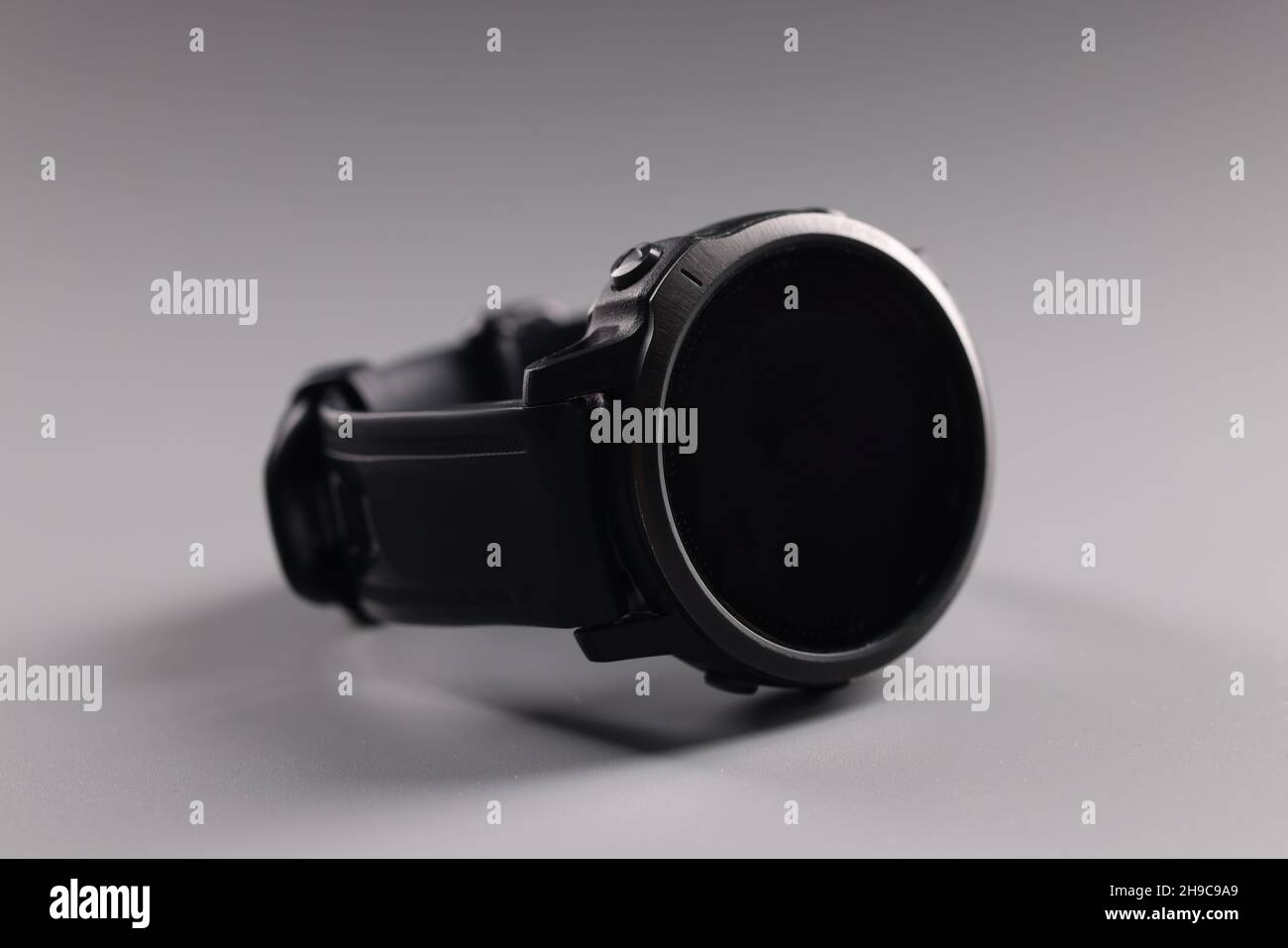 Montre de sport à poignet mâle couchée sur fond gris gros plan Banque D'Images
