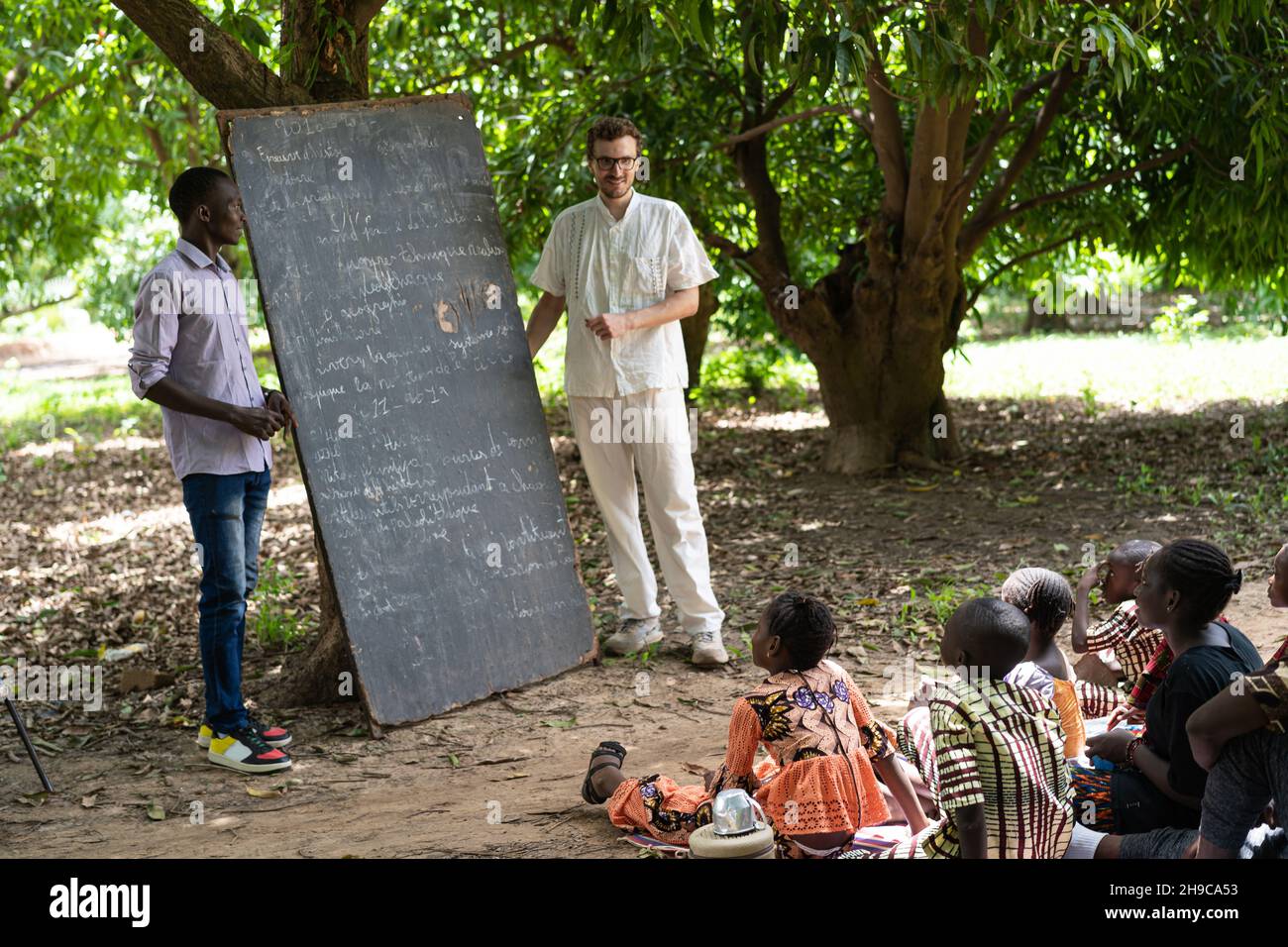 Enseigner dans une école d'été dans un village d'Afrique de l'Ouest isolé ; action humanitaire internationale, concept de volontariat Banque D'Images