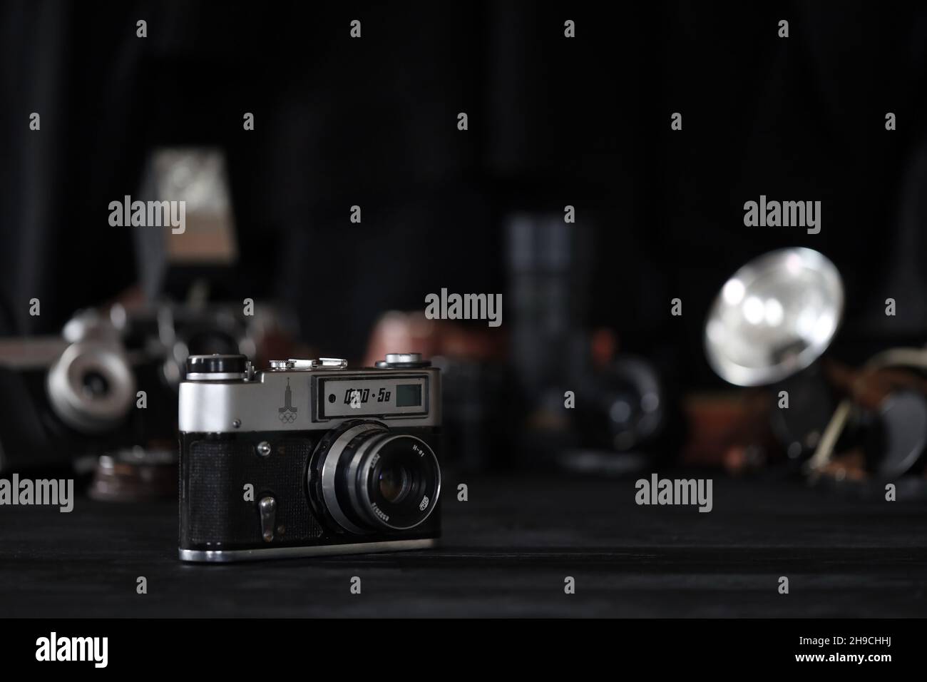 KHARKOV, UKRAINE - 27 AVRIL 2021: Fed 5b caméra de film et un autre vieux matériel photo rétro sur table en bois noir dans la chambre noire de photographe.Tél Banque D'Images