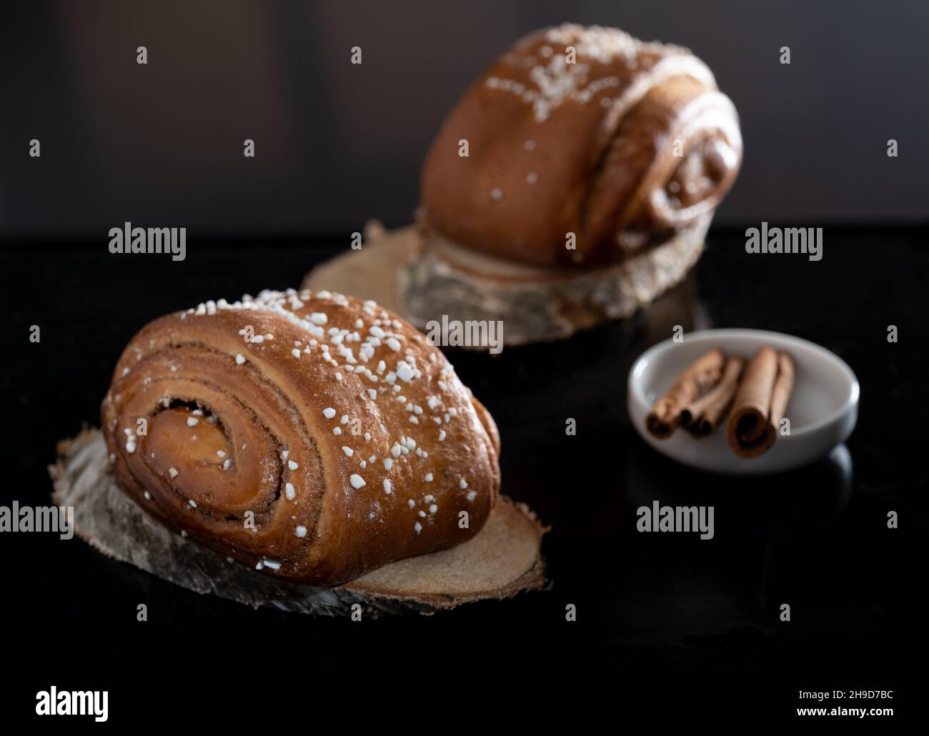 Helsinki / Finlande - 4 DÉCEMBRE 2021 : gros plan des petits pains à la cannelle finlandais traditionnels sur des dessous de verre en bois.Bâtonnets de cannelle. Banque D'Images