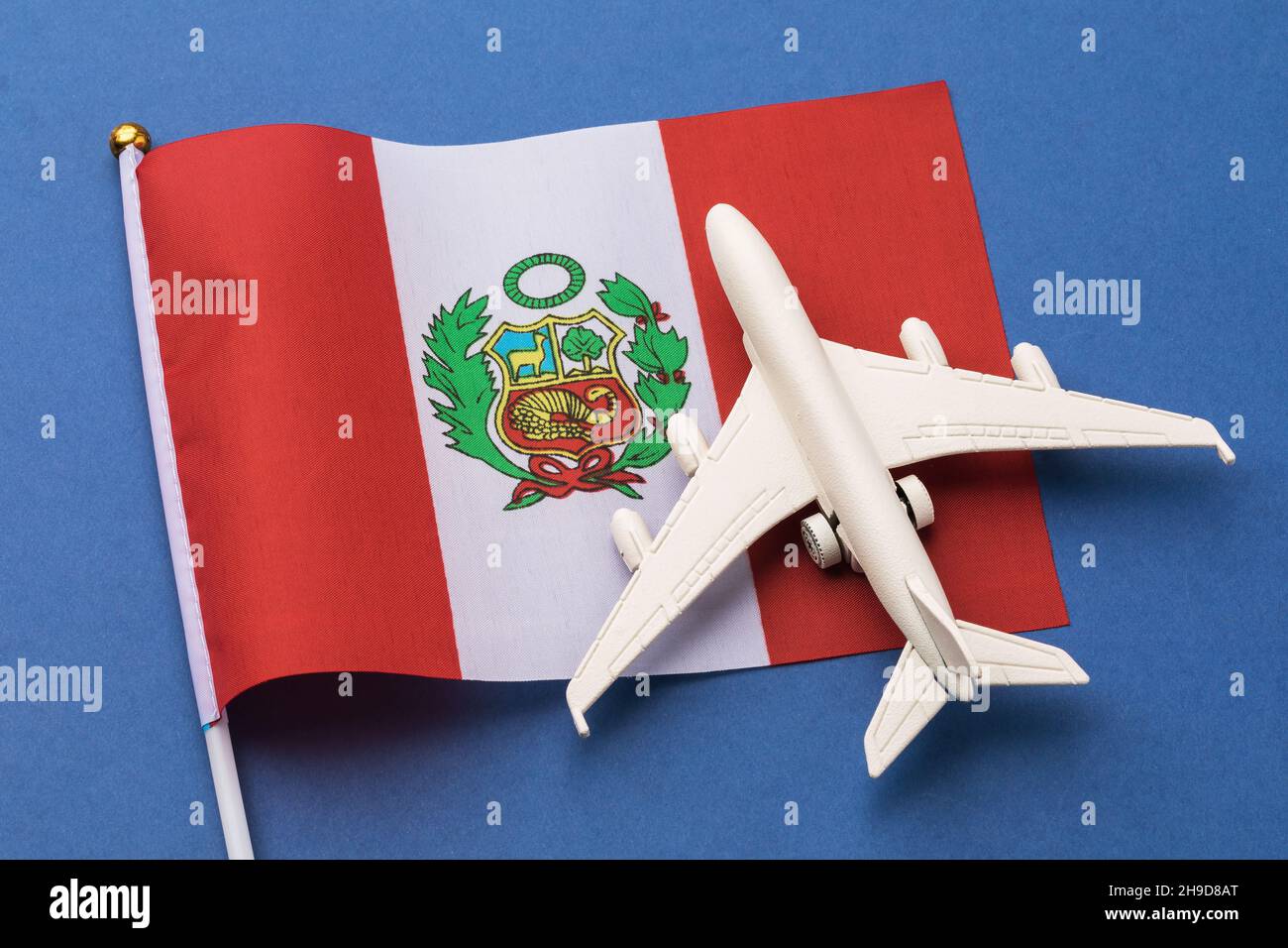 Drapeau péruvien et un avion jouet sur un fond coloré, le concept sur le thème du voyage au Pérou Banque D'Images
