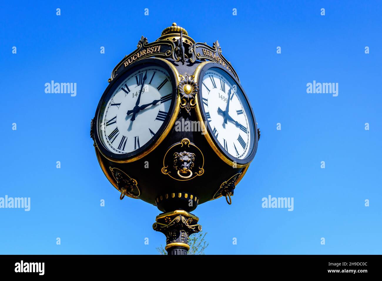 Horloge métallique noire et grise de style vintage vers ciel bleu clair dans le parc du Roi Michael I (ancien Herastrau) à Bucarest, en Roumanie, au printemps ensoleillé Banque D'Images