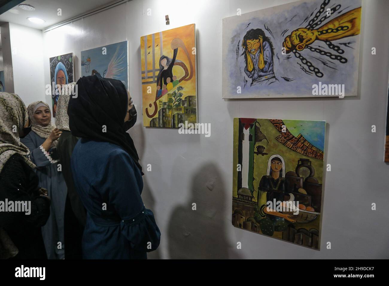 Les Palestiniens visitent une exposition d'art dans le cadre d'une campagne de sensibilisation à la violence à l'égard des femmes, dans la bande de Gaza, le 6 décembre 2021. Banque D'Images