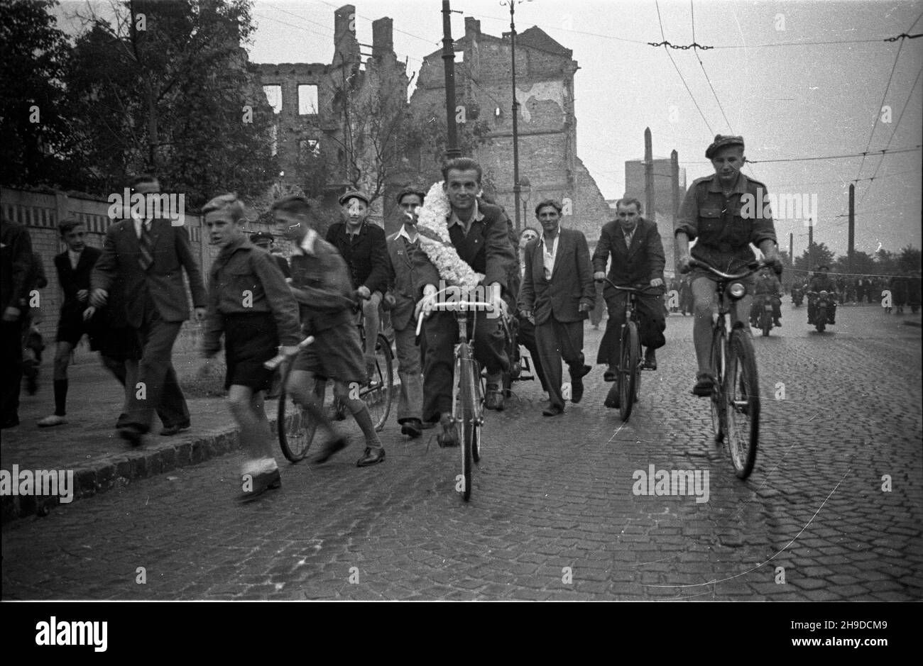 Varsovie, 1947-09-28.Pierwszy powojenny Wyœcig Kolarski Dooko³a Polski na trasie Kraków–Warszawa (VI Tour de Bologne).NZ. Udekorowany wieñcem zwyciêzca ca³ego wyœcigu - Stanis³aw Grzelak (C) z klubu Tramwajarz ódŸ, podczas rundy honorowej ulicami zniszczonej stolicy. bk/ppr PAPVarsovie, le 28 septembre 1947.Stade du club sportif militaire Legia.La première course cycliste autour de la Pologne après la guerre (VI Tour de Bologne) de Cracovie à Varsovie.Photo: Vainqueur de la course Stanisaw Grzelak du club Tramwajarz Lodz faisant un tour d'honneur. bk/mgs PAP Banque D'Images