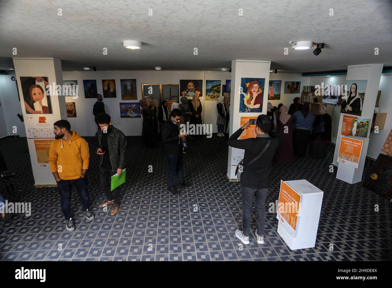 Les Palestiniens visitent une exposition d'art dans le cadre d'une campagne de sensibilisation à la violence à l'égard des femmes, dans la bande de Gaza, le 6 décembre 2021. Banque D'Images