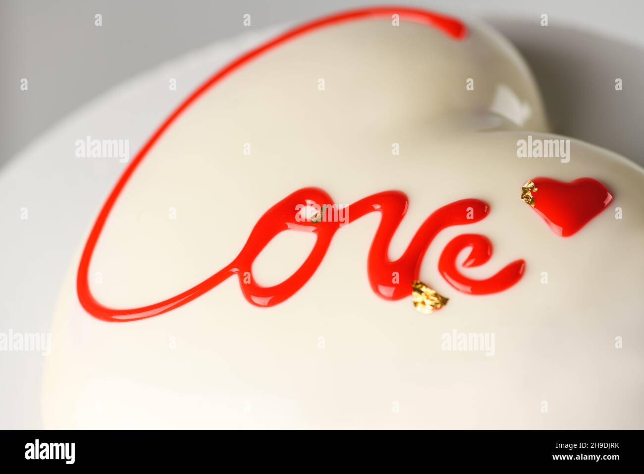Gâteau en forme de coeur avec inscription Love sur fond gris gros plan pour la Saint-Valentin et le 14 février Banque D'Images