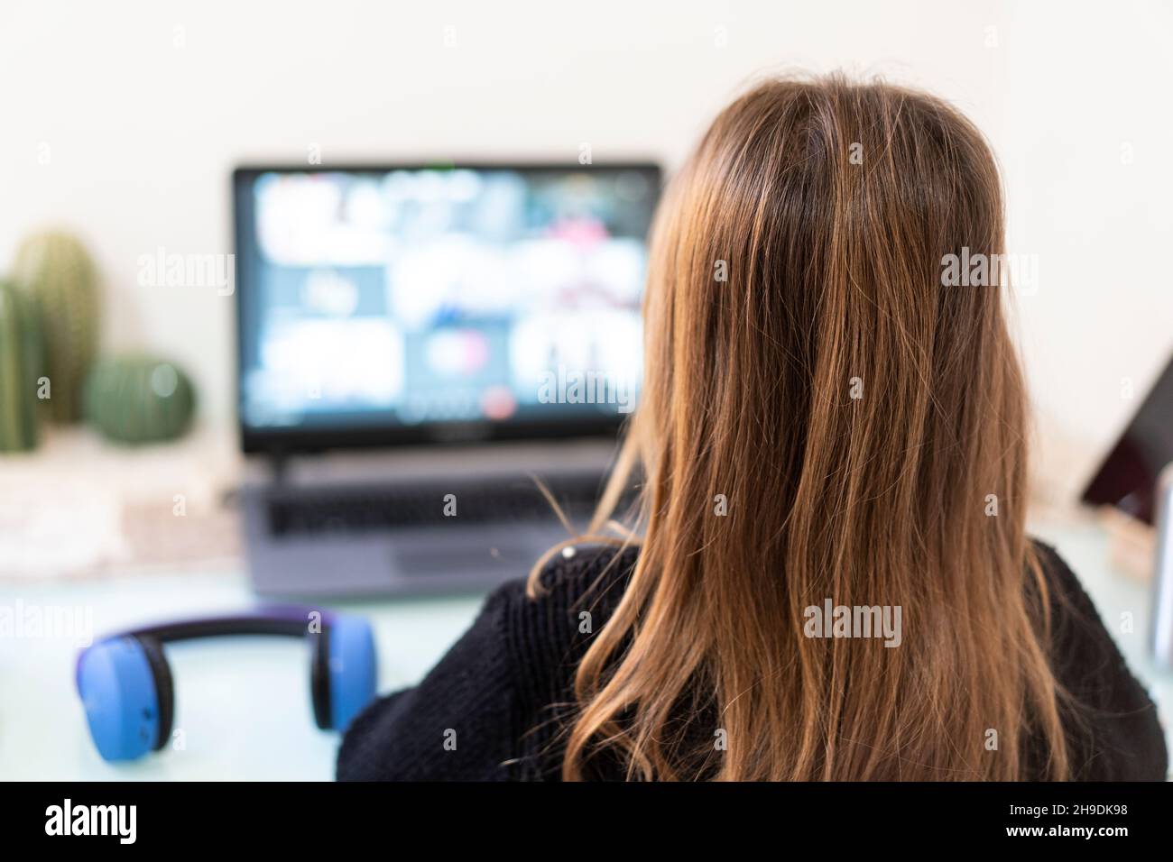 École primaire enfant fille à la maison avec un ordinateur portable pour la connexion à distance avec ses camarades de classe et le professeur - petite fille apprenant en utilisant les e-s d'Internet Banque D'Images