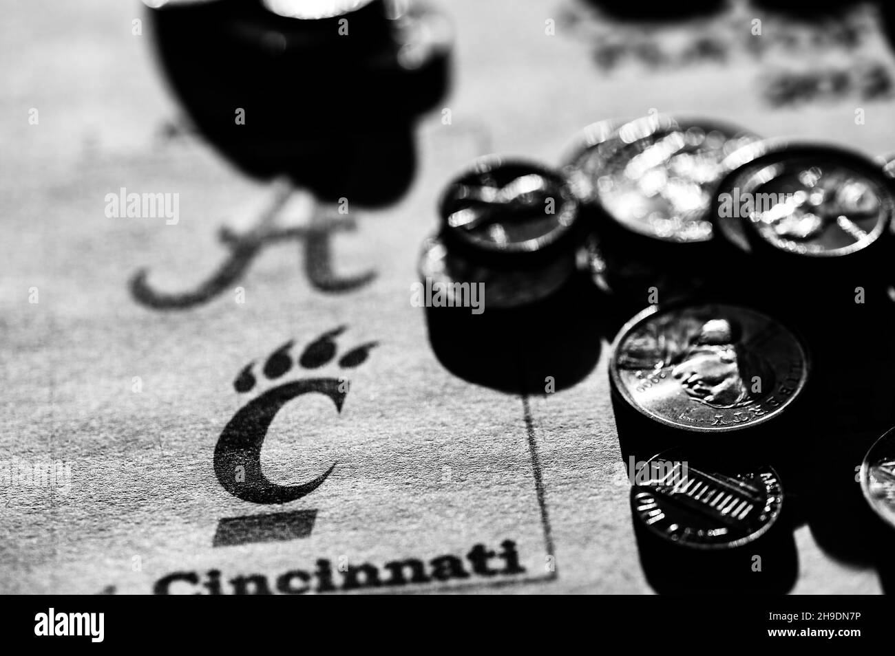 Tiffin, Iowa, États-Unis - 12.2022 - accent sélectif sur le support de jeu de football de l'université 2021-2022 avec pièces de monnaie éparpillées. Banque D'Images