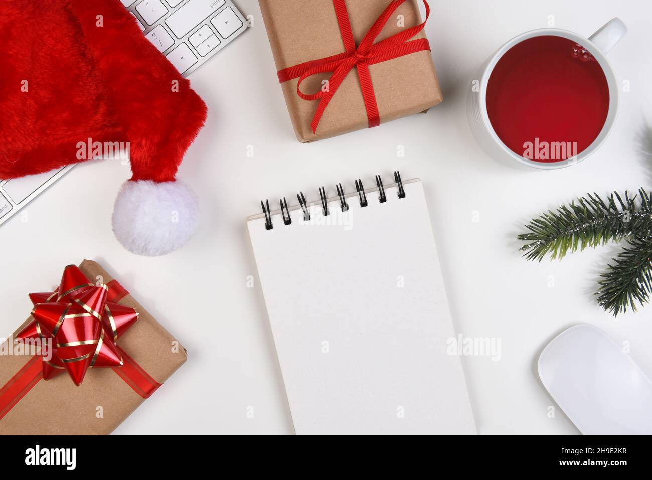 Concept de Noël à plat.Clavier d'ordinateur un bloc-notes vierge avec des cadeaux de Noël et une tasse de thé. Banque D'Images