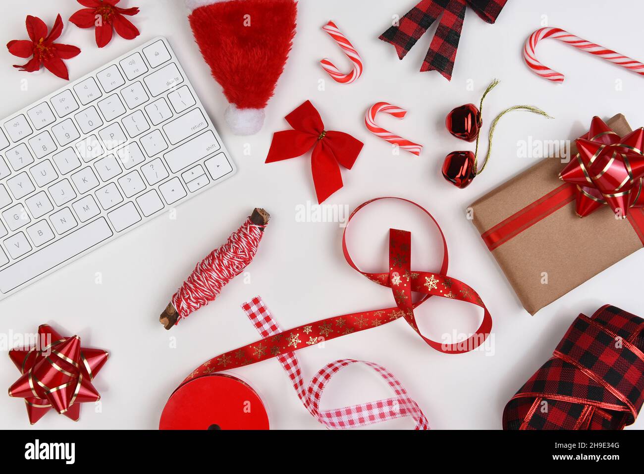 Plat de Noël.Rouge présenter les fournitures d'emballage, sur une table blanche, avec clavier d'ordinateur. Banque D'Images