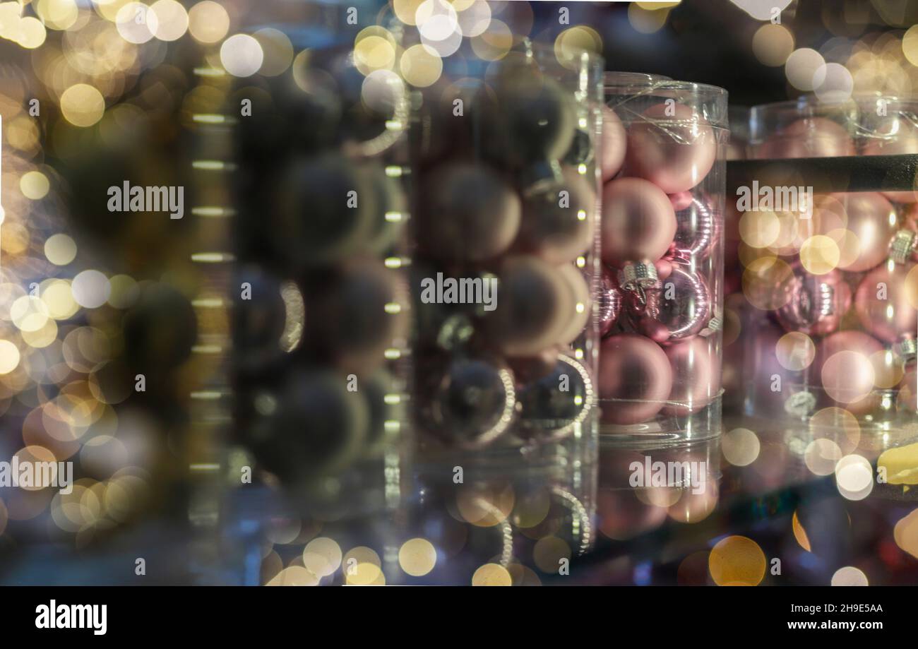 Boules de Noël décoration pour arbre de Noël closeup sur la tablette de magasin emballés dans des paquets dans des lumières de guirlande. Banque D'Images