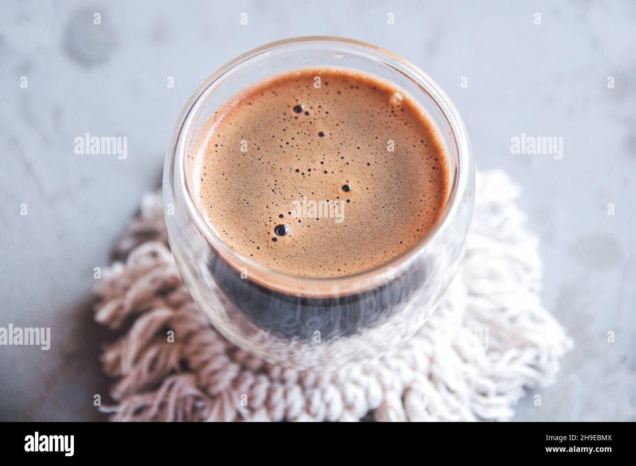 Café chaud en verre à double paroi sur fond gris Banque D'Images