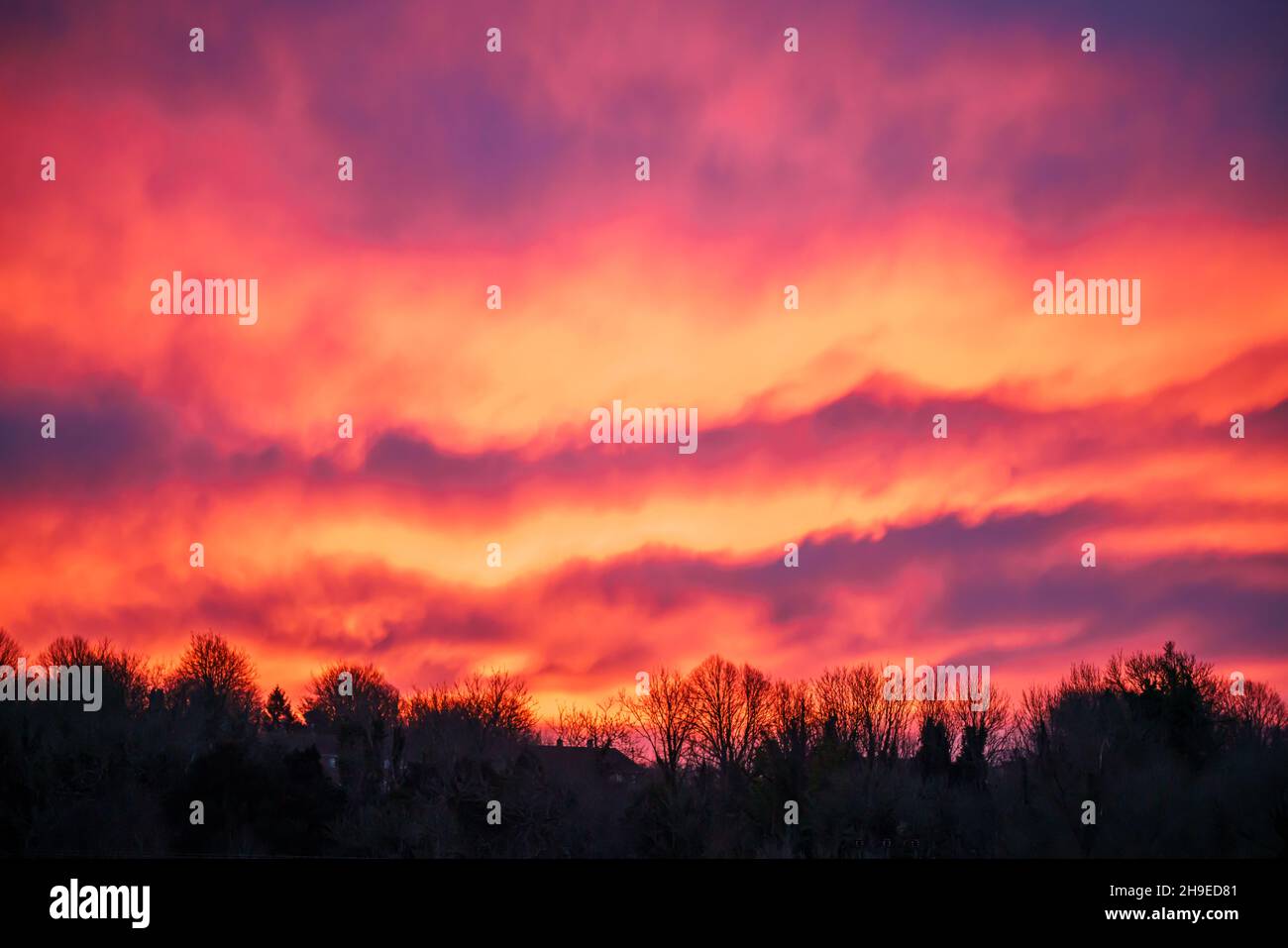 De belles vagues de lave flamboyante comme le nuage dans un ciel rouge vif, orange et jaune de lever du soleil, Wiltshire Royaume-Uni Banque D'Images