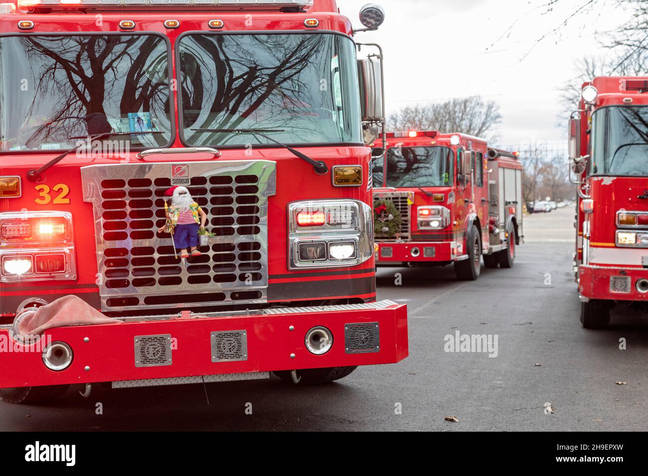Detroit, Michigan - Une poupée du Père Noël et une couronne décorent les camions d'incendie tandis que les pompiers combattent un feu de maison quelques semaines avant Noël. Banque D'Images