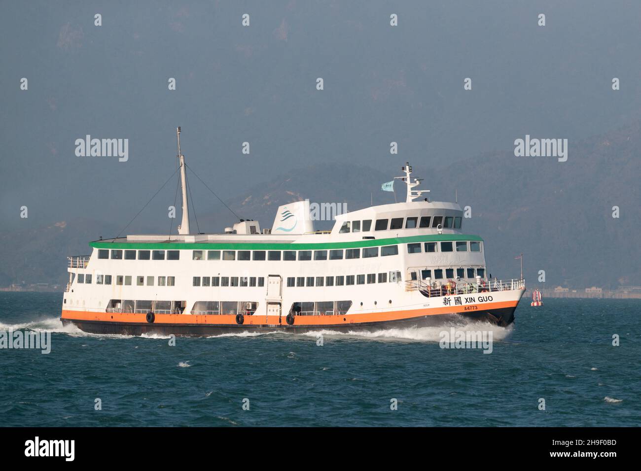 'Xin Guo' ('New Country') - un navire de la First Ferry Company qui traverse le port de Victoria de Cheung Chau au au centre de Hong Kong, 30th novembre 2021 Banque D'Images