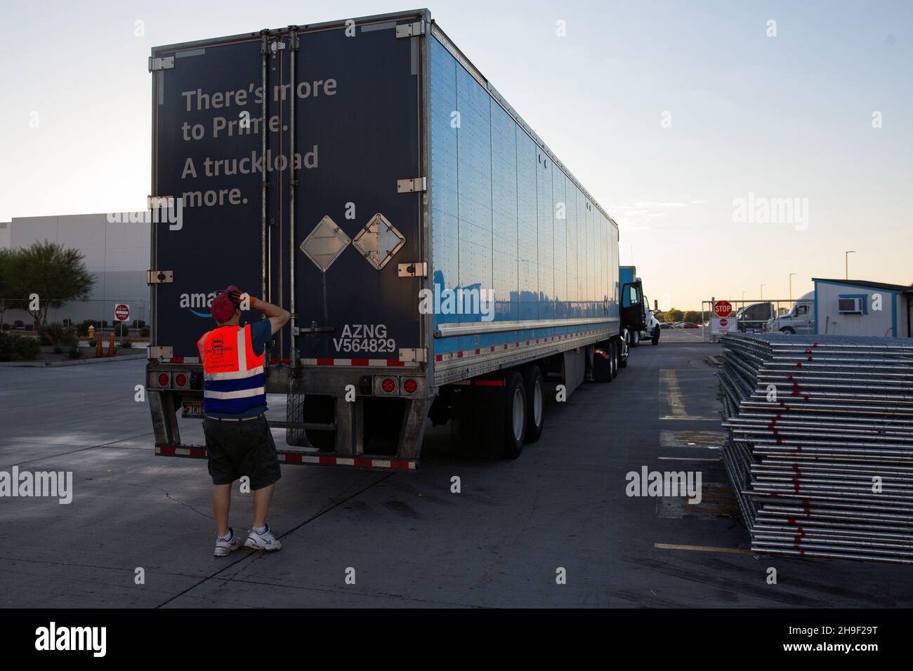 Le chauffeur de camion John Malozienc inspecte une remorque Amazon à  destination de Tucson dans un centre de distribution de Phoenix, Arizona,  États-Unis, le 2 décembre 2021.Photo prise le 2 décembre  2021.REUTERS/Caitlin