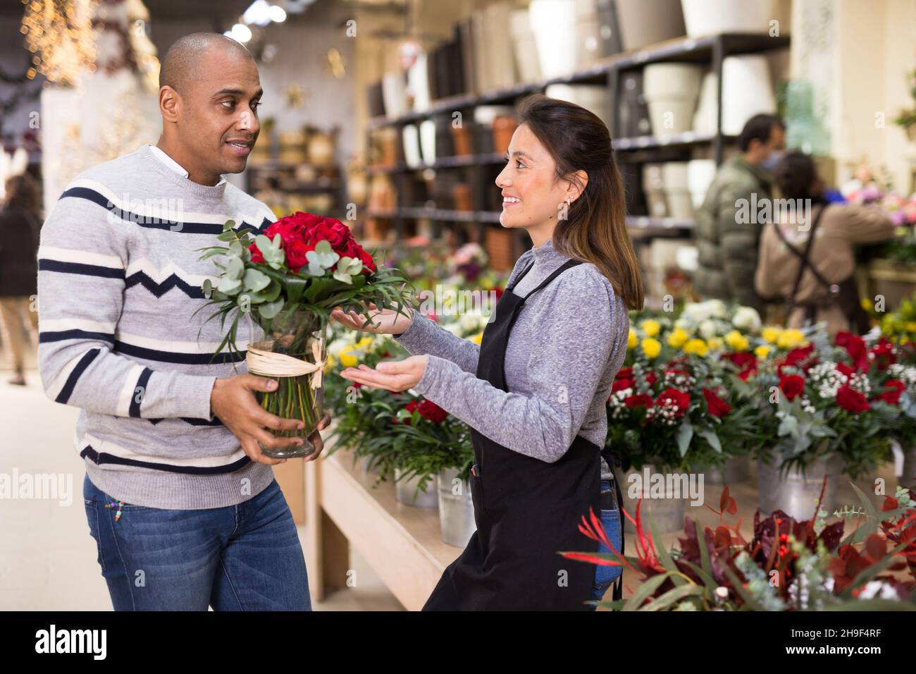 Propriétaire de fleuriste conseillant le client masculin avant l'achat de  fleurs Photo Stock - Alamy