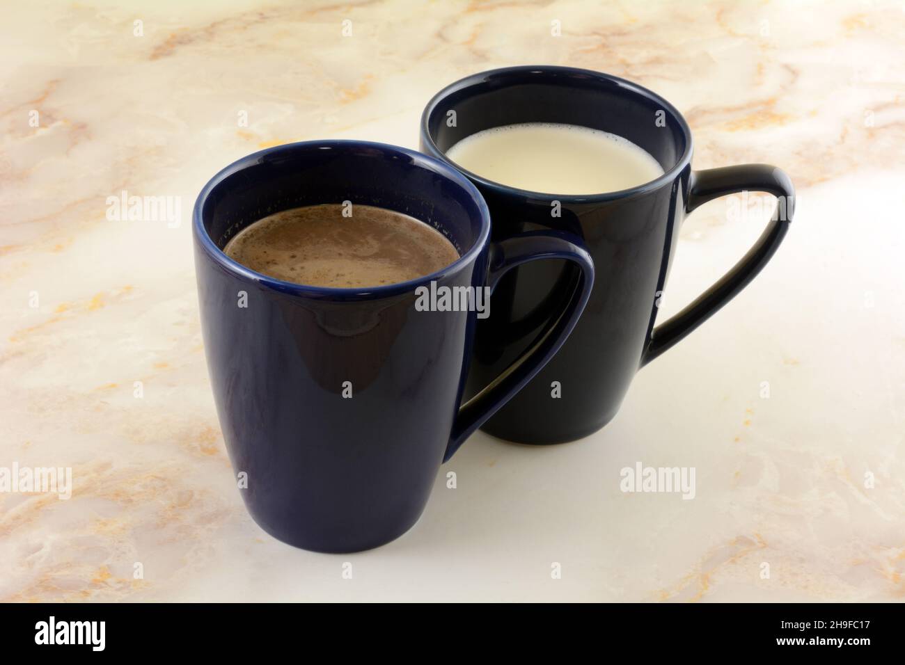 Chocolat chaud et boissons au chocolat blanc chaud dans des mugs bleus Banque D'Images