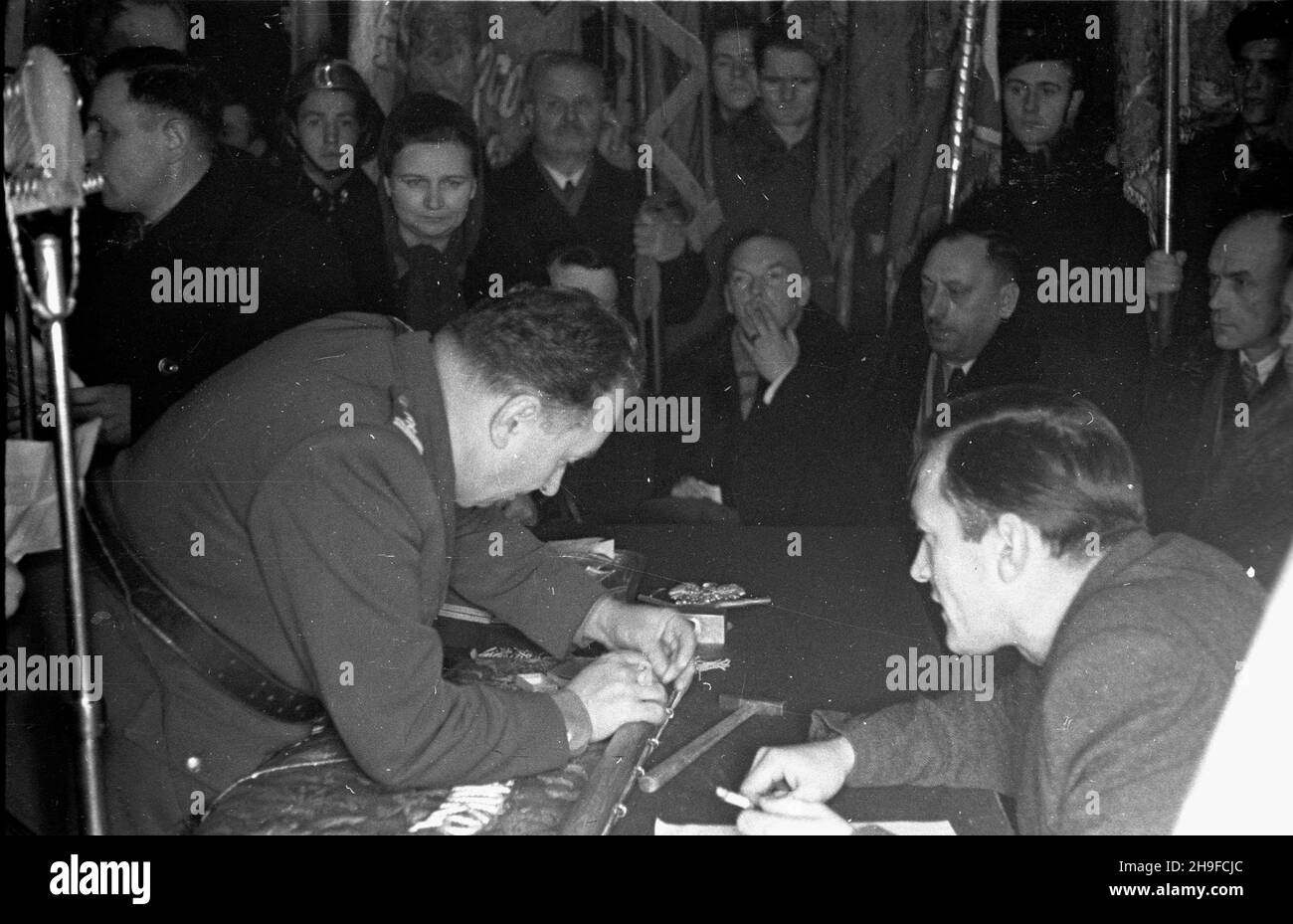Kutno, 1948-01-17.Trzeci¹ rocznicê oswobodzenia stolitcy uczczono wrêczeniem sztandaru ko³u Zwi¹zku Uczestnikchu Walki Zbrojnej (Z.U.W.) oraz udekorowaniem 98 cz³onków za czynny udzia³ W ruoporu.NZ. Wbicie symbocznego gwoŸdzia W drzewiec sztandaru. mw PAPKutno, 17 janvier 1948.Le 3e anniversaire de la libération de Varsovie a été commémoré avec la présentation d'une bannière à un cercle de l'Union des participants à la lutte armée (Z.U.W., Z) et la décoration de 98 membres pour leur participation au mouvement de résistance.Photo : un clou symbolique en train d'être conduit dans le poteau de la bannière. mw Banque D'Images