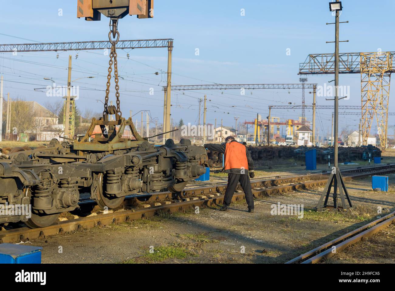 Postes de travail avec grue industrielle qui lève les roues motrices pour le train Banque D'Images