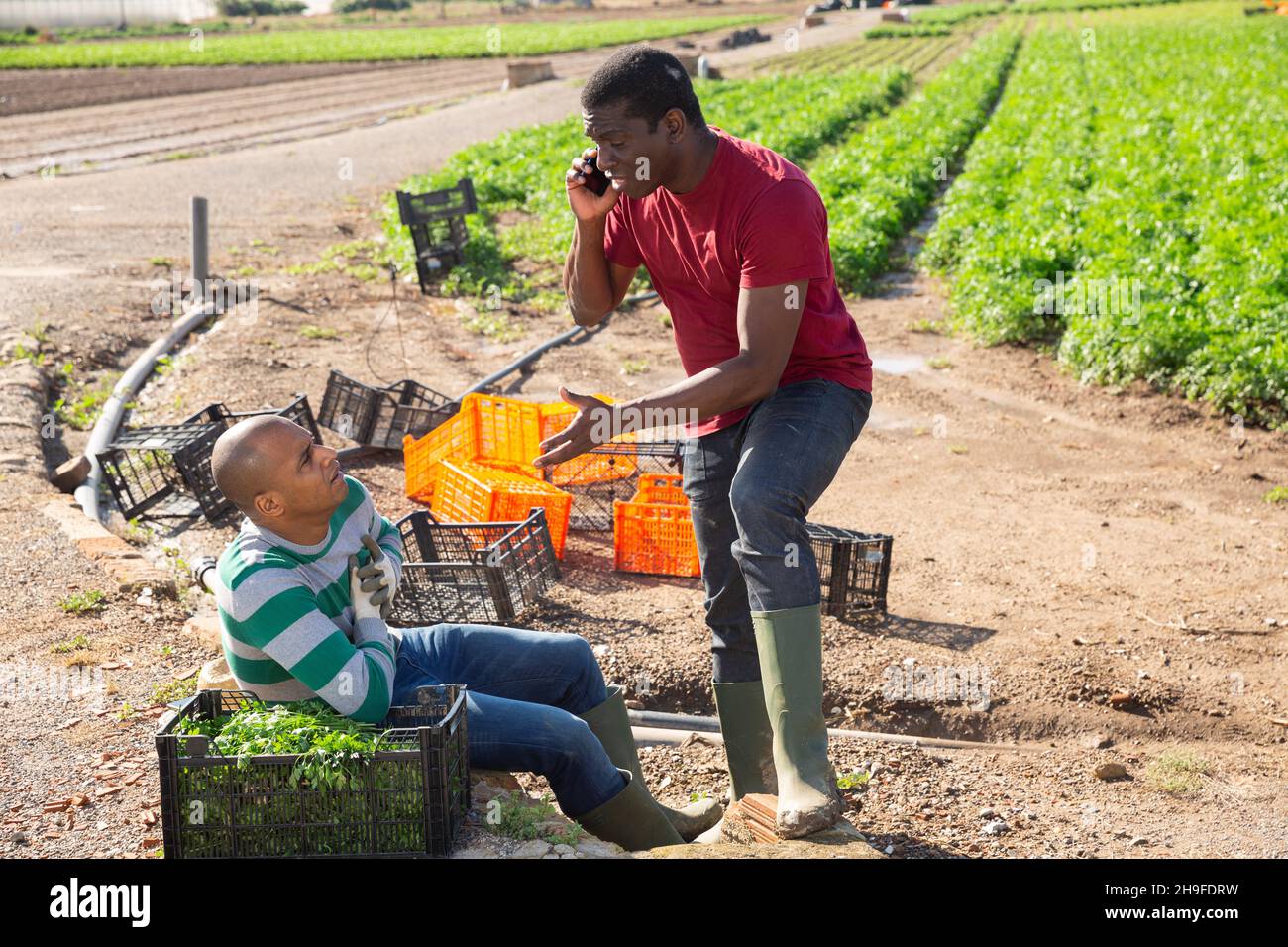Jardinier afro-américain appelant un professionnel de la santé pour un ami hispanique Banque D'Images