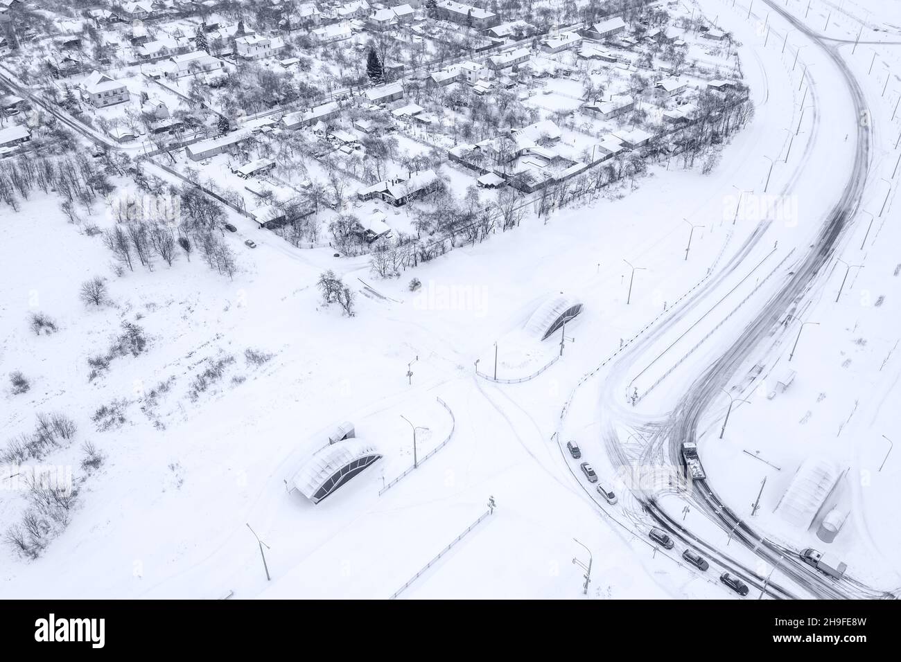 quartier résidentiel de banlieue avec maisons enneigées et arbres en hiver. photo de drone aérien. Banque D'Images