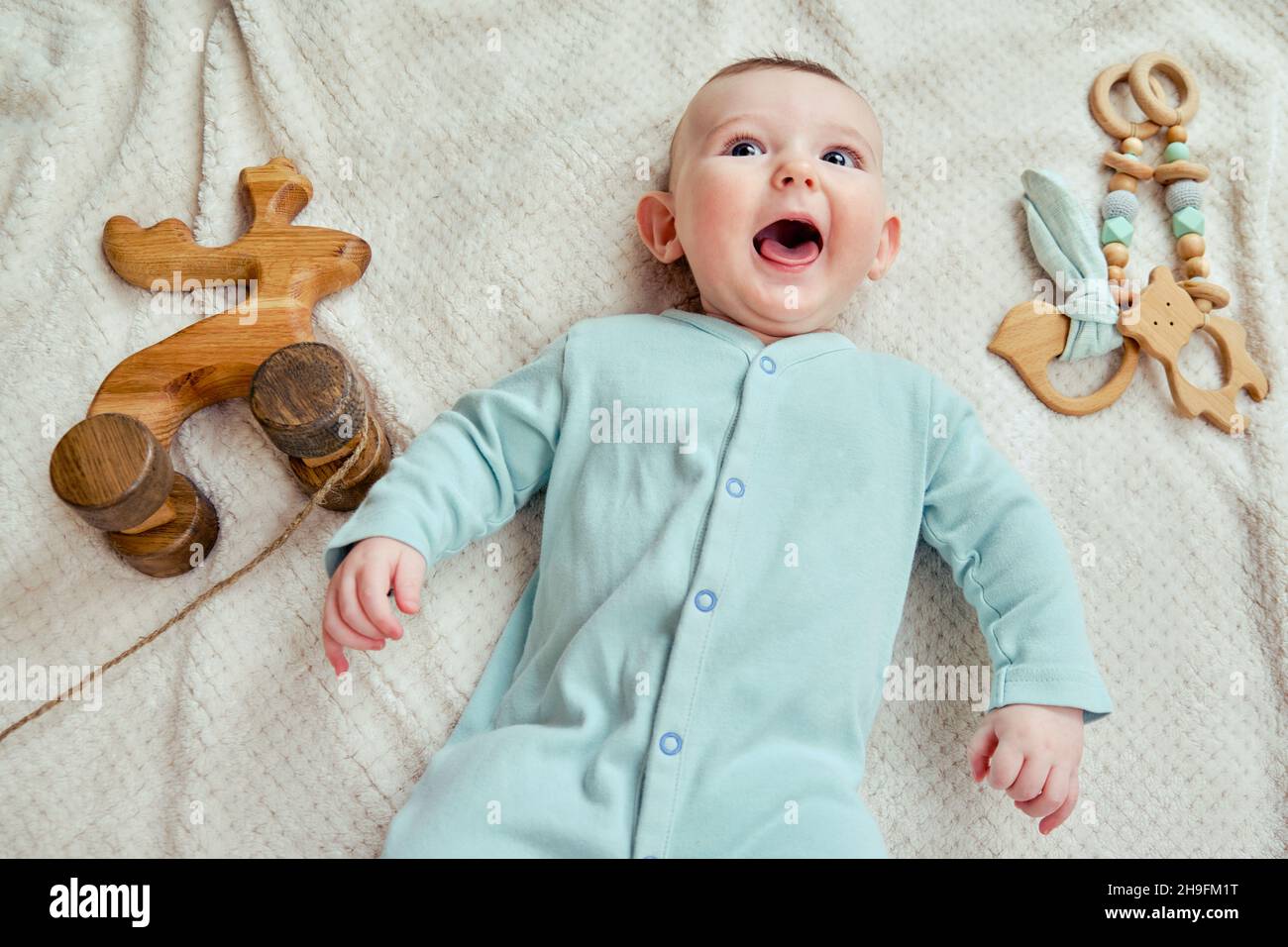 Bebe Heureux Repose Sur Une Couverture En Vetements De Couleur Menthe Avec Des Jouets En Bois Enfant Souriant En Pyjama Turquoise Vue Du Dessus Photo Stock Alamy