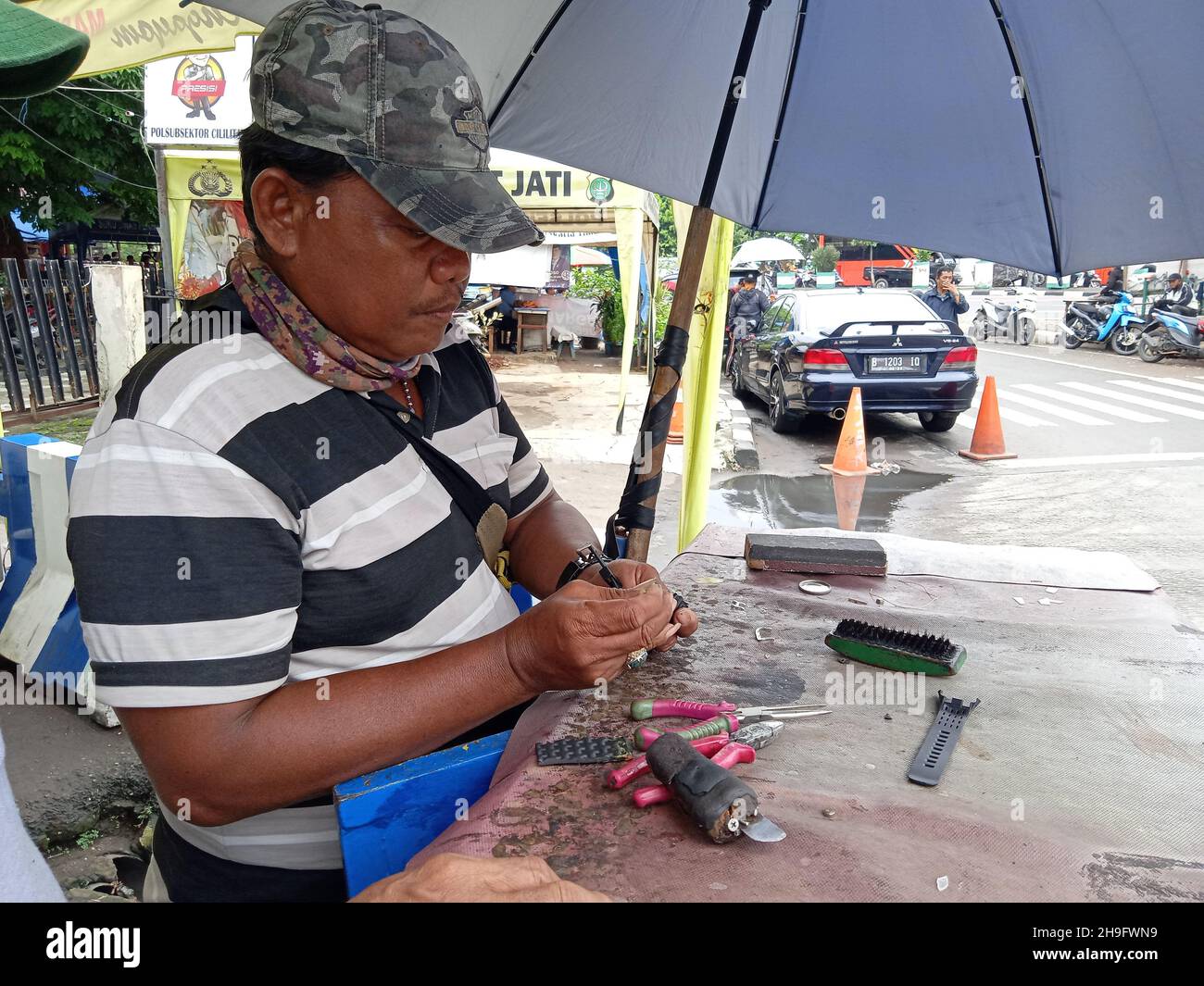 Photo éditoriale, Indonésie, Djakarta orientale, Kramat Jati, 12 décembre 2021,Homme en réparation ou en remplacement de la montre à bracelet du client Banque D'Images