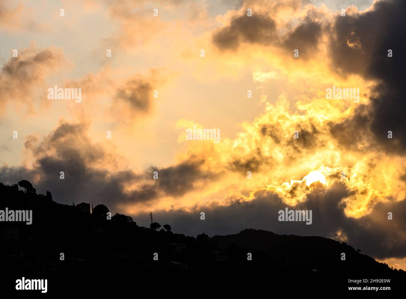 Le soleil supplie les nuages de tirer le ciel avec la colline en contre-jour Banque D'Images
