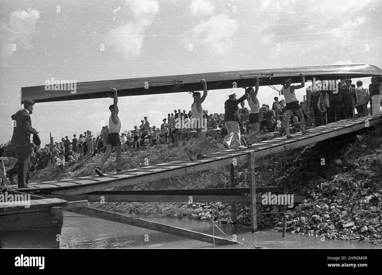 Varsovie, 1948-06-27.Regaty na Wiœle zorganizowane z okazji jubileuszu siedemdziesiêciolecia istnienia Warszawskiego Towarzystwa Wioœlarskiego.W obchodach wziêli udzia³ m.in. Prezes WTW Jerzy Loth jako jeden z sêdziów zawodów obok S. Kopczyñskiego i S. Archówny.NZ. Zawodnicy czwórki mêskiej wnosz¹ ³ódŸ na brzeg. uu PAPVarsovie, le 27 juin 1948.Une régate sur la Vistule organisée à l'occasion du 70e anniversaire de la Société d'aviron de Varsovie (WTW).Le président du WTW, Jerzy Loth, était juge à l'événement, avec S. Kopczynskiego et S. Architowa.Photo : quatre concurrents pour hommes portant le Banque D'Images