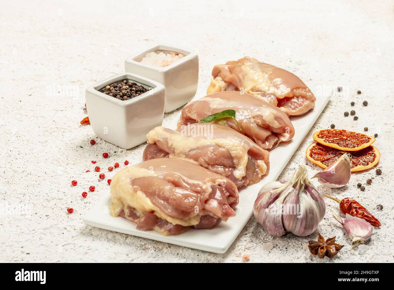 Cuisse de poulet crue sans os ni peau.Un ingrédient utile pour préparer des aliments sains, des épices, de l'ail.Arrière-plan léger, espace de copie Banque D'Images