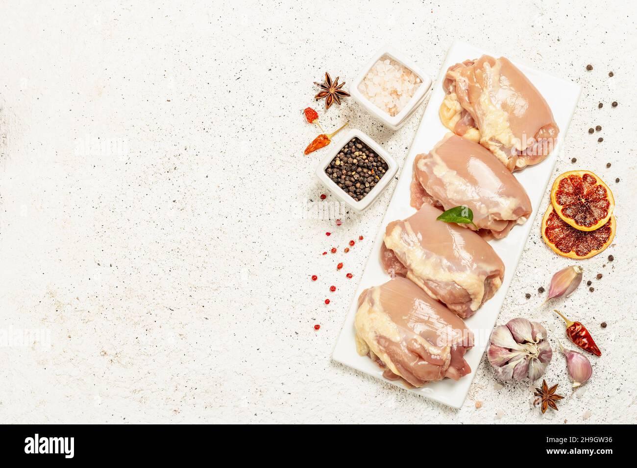 Cuisse de poulet crue sans os ni peau.Un ingrédient utile pour préparer des aliments sains, des épices, de l'ail.Arrière-plan léger, vue de dessus Banque D'Images